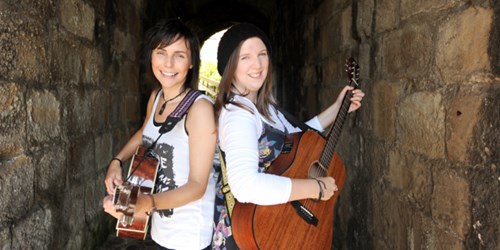 the Coaltown Daisies - two women standing back to back with guitars